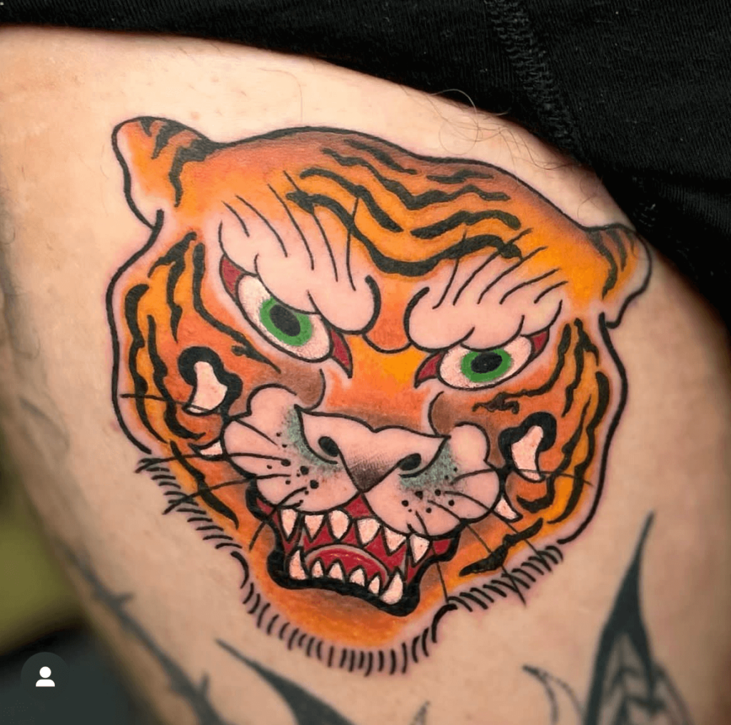 Good Quality Traditional Japanese Tiger Tattoo by Joao Tereso with green eyes and yellow and orange fur.